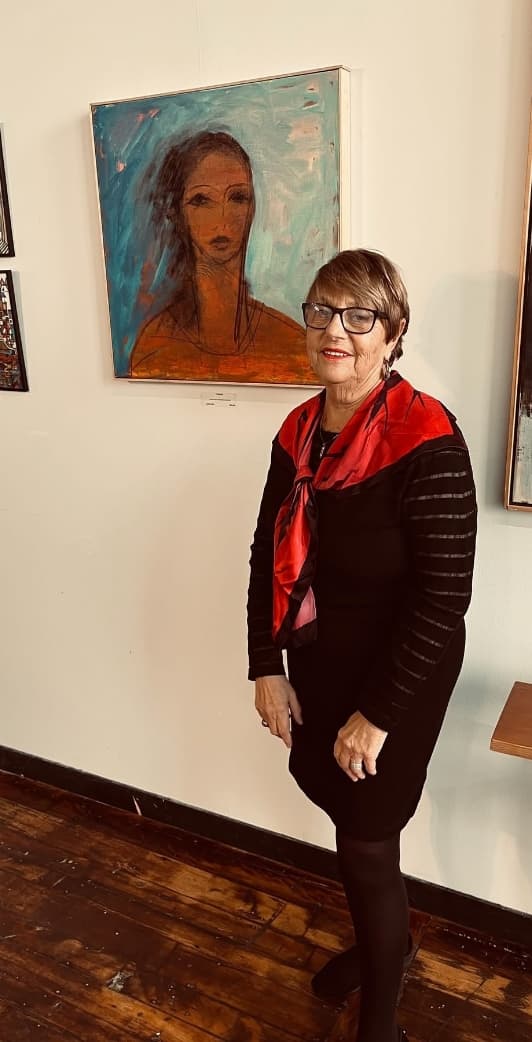 An Artist standing next to her art work.